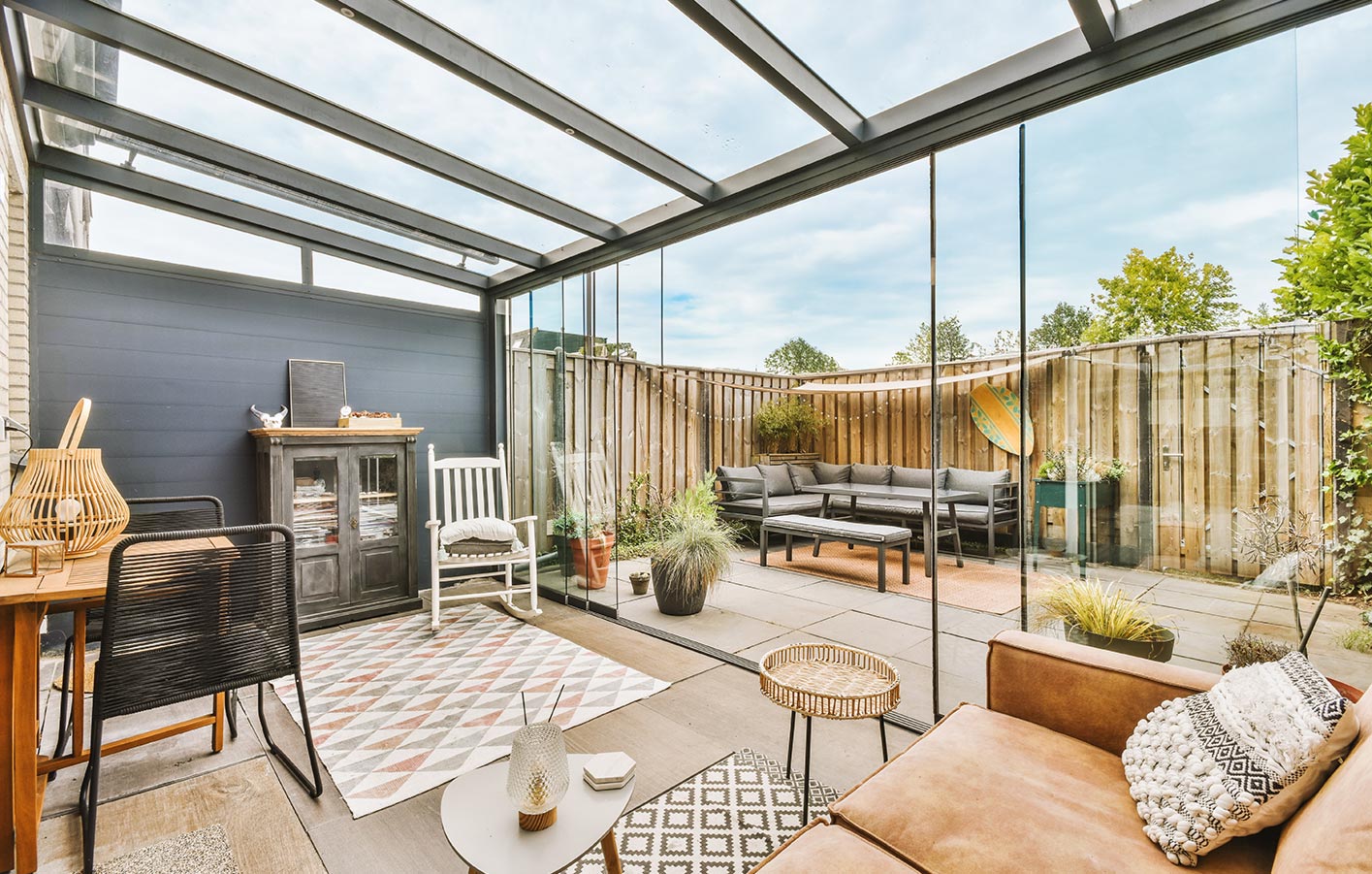 Überdachte Terrasse als erweitertes Wohnzimmer mit Möbeln und dekorativen Elementen